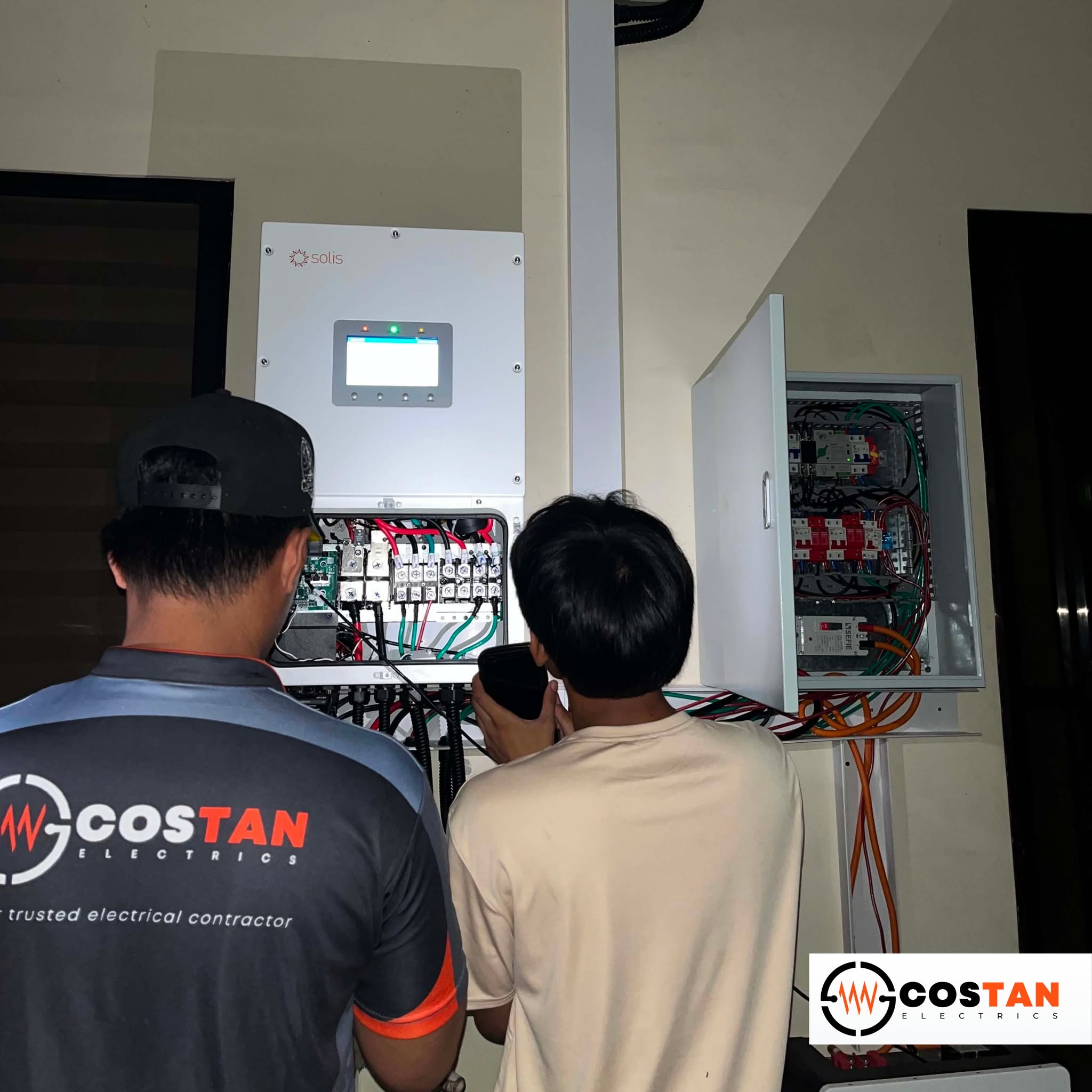 Costan Electrics technicians commissioning the hybrid solar control panel in Baclayon, Bohol